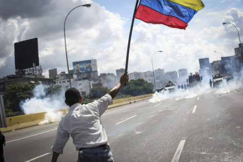 Opposition activists clash with the riot police as they block the Francisco Fajardo highway in Caracas during a demonstration against President Nicolas Maduro's government on May 29, 2017. Demonstrations that got underway in late March have claimed the lives of 59 people, as opposition leaders seek to ramp up pressure on Venezuela's leftist president, whose already-low popularity has cratered amid ongoing shortages of food and medicines, among other economic woes. <i>Photo by Sipa via AP Images</i>