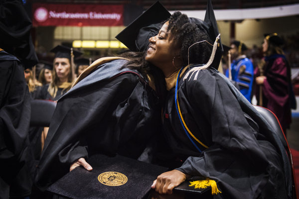 Graduates share a hug after receiving their diplomas at Thursday's graduation ceremony. Photo by Adam Glanzman/Northeastern University
