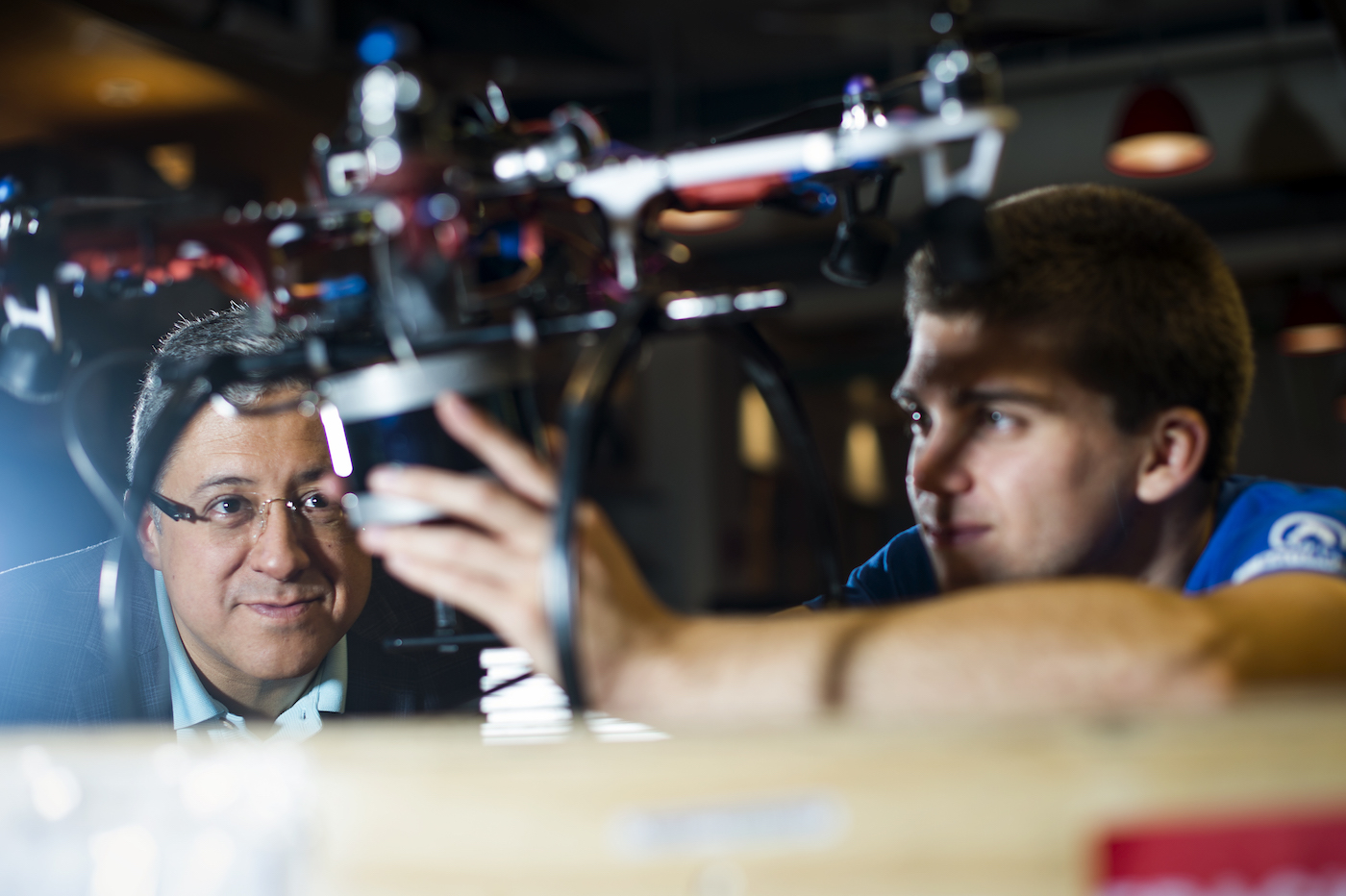 Taskin Padir and his student Nicolas Binford work on a hexi-copter drone. Padir's lab is developing aerial robots for damage detection after disasters. Photo by Adam Glanzman/Northeastern University