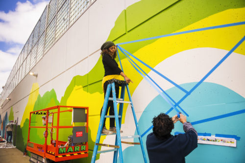 05/14/18 - BOSTON, MA. Silvia Lopez Chavez installs a new campus mural on the MBTA wall across from Centennial Common on May 8, 2018. Photo by Adam Glanzman/Northeastern University