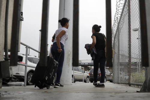 Sisters from Guatemala seeking asylum cross a bridge to a port of entry in to the United States from Matamoros, Mexico, on Wednesday, June 20, 2018. (AP Photo/Eric Gay)