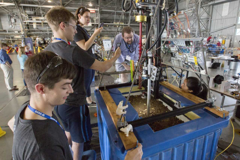 Northeastern engineering students work on a robotic device to extract water from the ice trapped below a simulated surface of Mars. Photo by NASA Langley / David C. Bowman