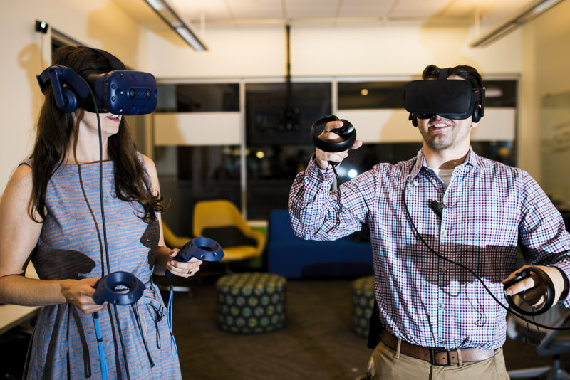 Lindsey Sudbury, an academic instructional technologist, and Ryan Bender, supervisor of IT Student Operations, test out virtual reality headsets in a new pop-up lab space in Snell Library where faculty and staff can learn how to use augmented reality, virtual reality, and 360 video equipment, on Sept. 17, 2018. Photo by Adam Glanzman/Northeastern University