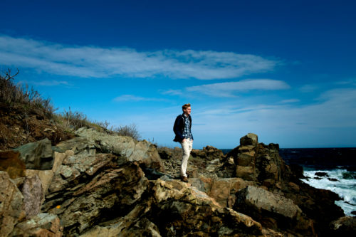 Ben Moran stands on the rocky shore at Northeastern’s Marine Science Center in Nahant, Massachusetts. Photo by Matthew Modoono/Northeastern University