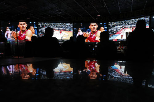 People watch coverage of the first round of the NCAA college basketball tournament at the Westgate Superbook sports book, Thursday, March 15, 2018, in Las Vegas. (AP Photo/John Locher)