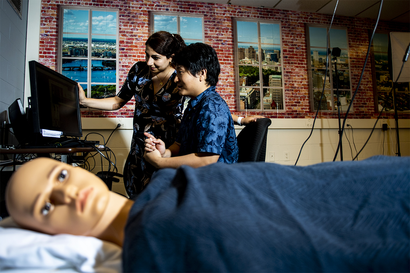 Sarah Ostadabbas, an assistant professor of electrical and computer engineering, and doctoral student Shuangjun Liu use a manikin to test their camera setup. Photo by Ruby Wallau/Northeastern University