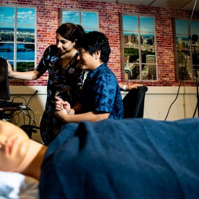 Sarah Ostadabbas, an assistant professor of electrical and computer engineering, and doctoral student Shuangjun Liu use a manikin to test their camera setup. Photo by Ruby Wallau/Northeastern University