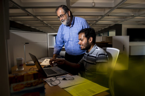 Herbert Levine, University Distinguished Professor of Physics, looks over research with graduate student Shubham Tripathi in the new Center for the Physics Underlying Mammalian Biology and Complex Diseases. Photo by Ruby Wallau/Northeastern University