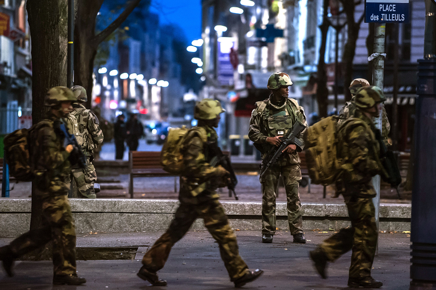 Special Police, Army, and other units move toward the scene in Paris suburb Saint-Denis on Wednesday, Nov. 18, 2015. Heavily armed police surrounded a suburban Paris apartment in a raid targeting the suspected mastermind of the Paris attacks. Credit: KAMIL ZIHNIOGLOU/Sipa via AP Images
