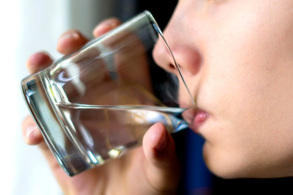 close up teenager drinking pure water from glass f