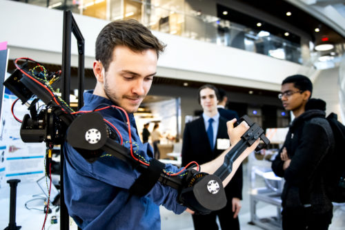 Karl Swanson, who studies computer engineering and computer science, tries out the Avatar XPRIZE arm during the mechanical engineering capstone showcase at the Interdisciplinary Science and Engineering Complex. Photo by Ruby Wallau/Northeastern University