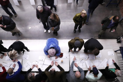 Caucus-goers check in at a caucus at Roosevelt Hight School, Monday, Feb. 3, 2020, in Des Moines, Iowa. (AP Photo/Andrew Harnik)