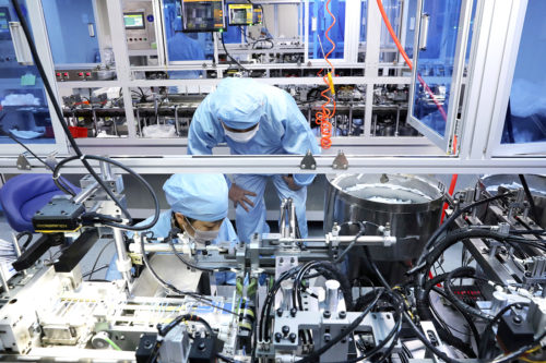 People work on the production line of SARS-CoV-2 testing kits in a biopharmaceutical company in Nantong city in east China's Jiangsu province Monday, March 09, 2020.  (FeatureChina via AP Images)