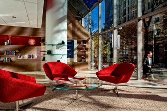 Red chairs inside of a building with tall windows.