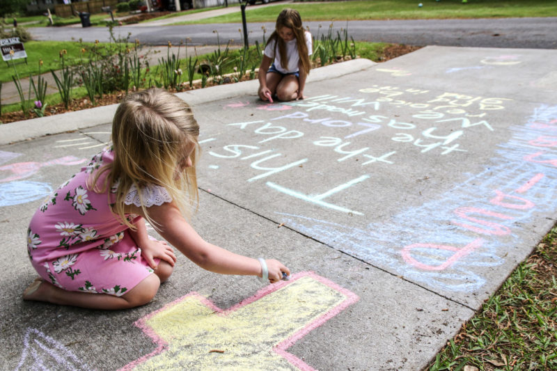 Lauren Vollor, left, 5, and her sister Anne Larkin Vollor, 8, chalk their driveway on in Meridin, Miss., on March 25, 2020. Children in the neighborhoods are writing new messages each day for inspiration to cope with the COVID-19 pandemic. AP Photo by Paula Merritt/The Meridian Star