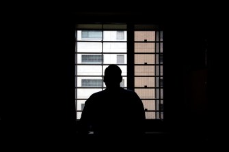 An inmate looks out a prison window.