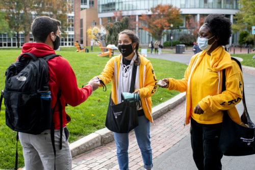 Healthy Husky Leaders Erin Cowden and Akosua Boateng, handout protective face masks and hand sanitizer on Centennial Common. Photo by Matthew Modoono/Northeastern University