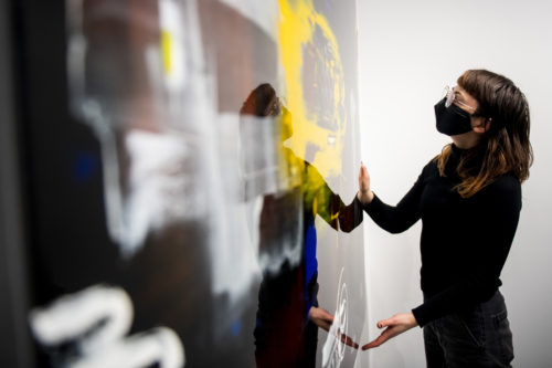 Art handler Elena Brunner installs a piece from artist MAR for the Dream Boston exhibition at Gallery 360. Photo by Ruby Wallau/Northeastern University