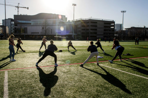 Members of Northeastern’s Chaarg fitness club for women work out on Carter Field. Photo by Ruby Wallau/Northeastern University