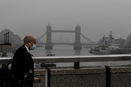 A commuter in protective face mask is seen crossing London Bridge at sunrise on March 2, 2021. AP Photo by Dominika Zarzycka/NurPhoto