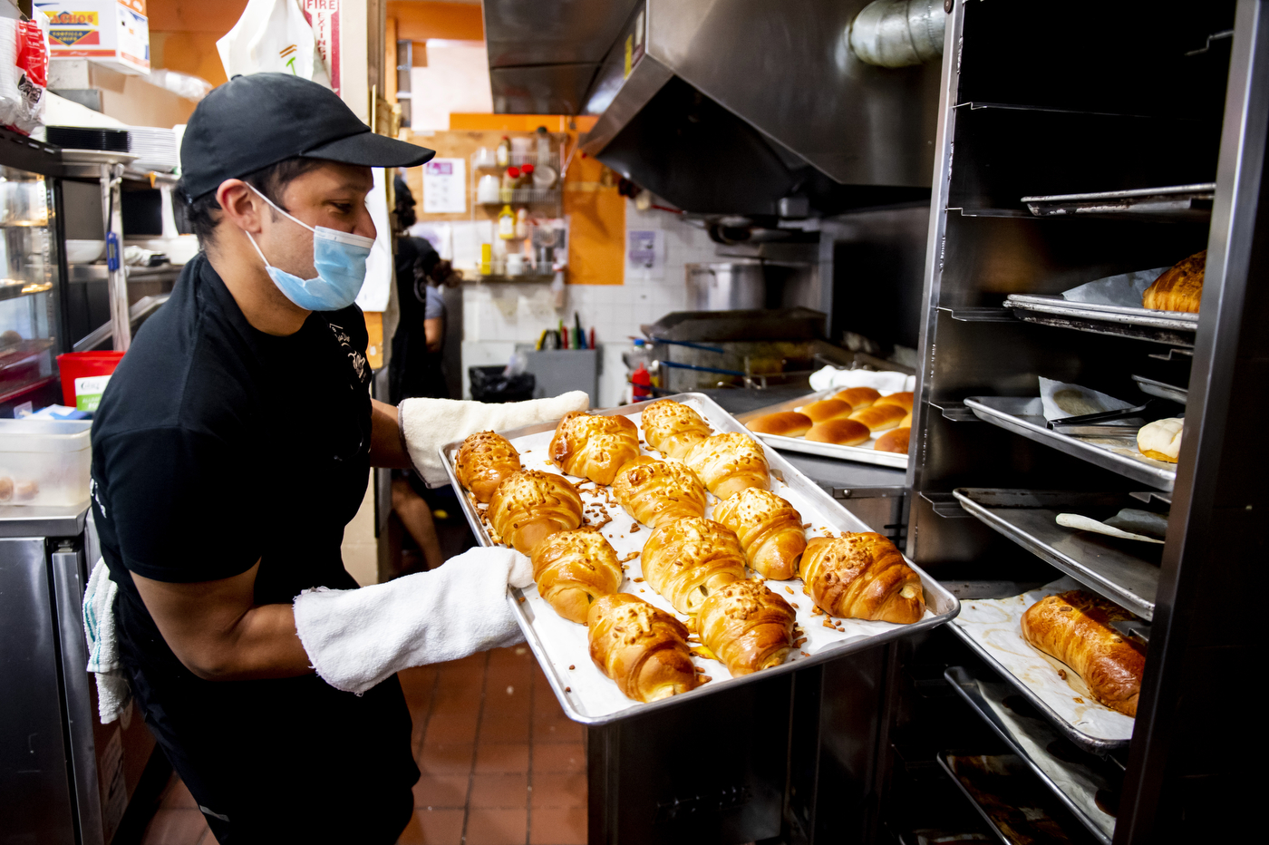 Fernando Rosas pulls freshly-baked bread from the oven.