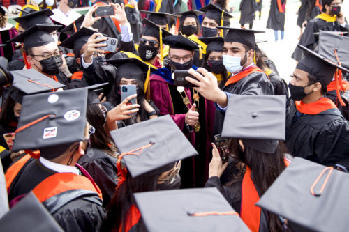Joseph E. Aoun, president of Northeastern, takes a selfie with graduates at the conclusion of the 2021 Commencement ceremonies at Fenway Park. Photo by Matthew Modoono/Northeastern University