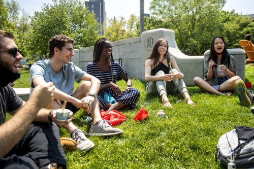 Students sitting on the grass on theBoston campus