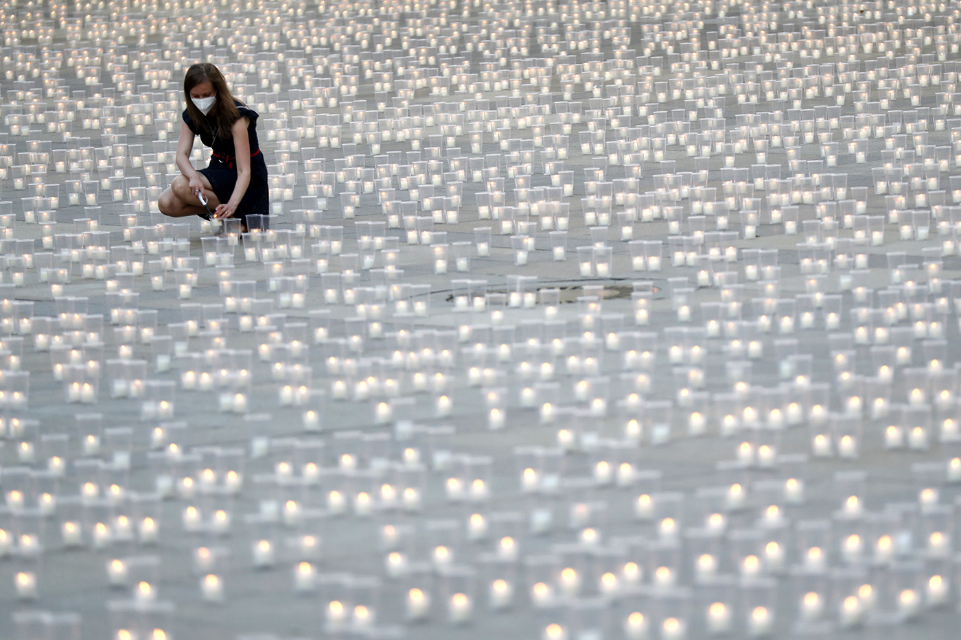 A woman lights a candle to commemorate victims of the COVD-19 pandemic at the Prague Castle in Prague, Czech Republic on May 10, 2021.
