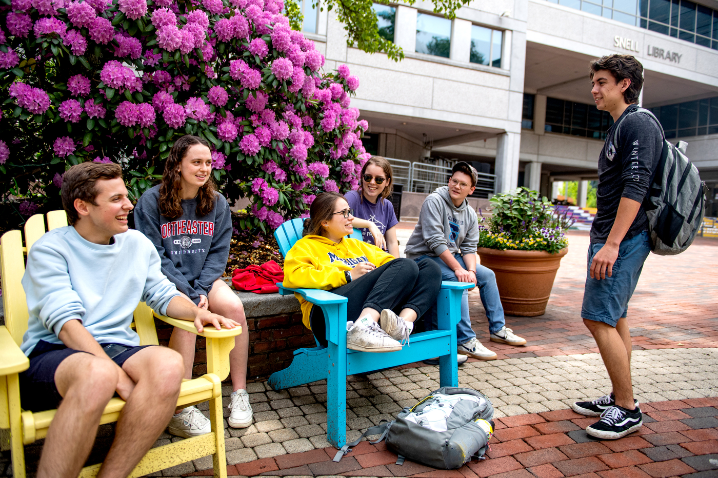A group of mechanical engineering students hang out in front of Snell Library.