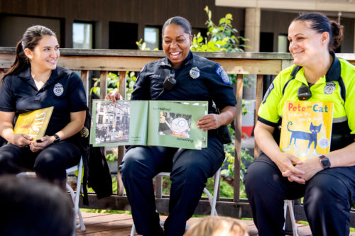 Northeastern University Police Officers, Brenda Zirpolo, Anika Crutchfield and Rachel Jolliffe, read to members of the community during a story time session at Carter Playground. Photo by Matthew Modoono/Northeastern University