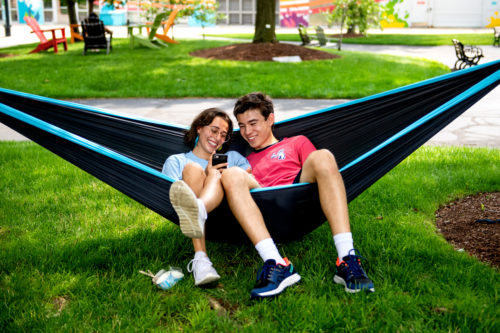 Amanda Vasconcelos and Quinlan McDonnell, who both study mechanical engineering, relax in a hammock on Centennial Common. Photo by Matthew Modoono/Northeastern University