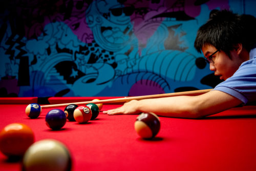 Zaili Ding, who studies math, plays pool in the Curry Student Center game room. Photo by Matthew Modoono/Northeastern University