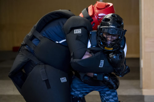 A Northeastern University youth police academy cadet fights off a pretend assailant played by a Northeastern University police officer during a self-defense class simulation. Photo by Alyssa Stone/Northeastern University