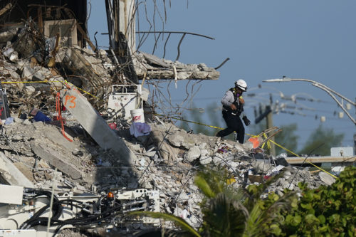As members of the search and rescue personnel work atop the rubble at the Champlain Towers South condo building, investigators are trying to understand the causes. AP Photo/Mark Humphrey