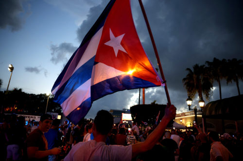 A man waves a Cuban flag in the street near of Versailles, a Cuban restaurant in the Little Havana neighborhood, at a demonstration in support of the protests in Cuba on July 11, 2021 in Miami, Florida. Thousands took to the streets across Cuba to protest pandemic restrictions, the pace of Covid-19 vaccinations and the Cuban government. Photo by Anna Moneymaker/Getty Images