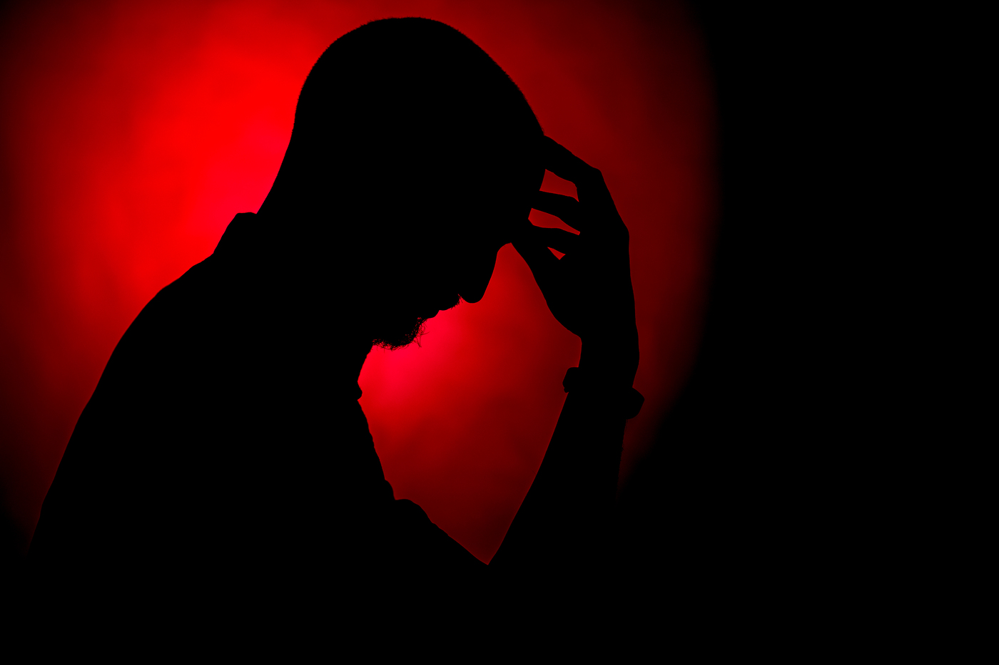 Silhouette of a man with his head lowered