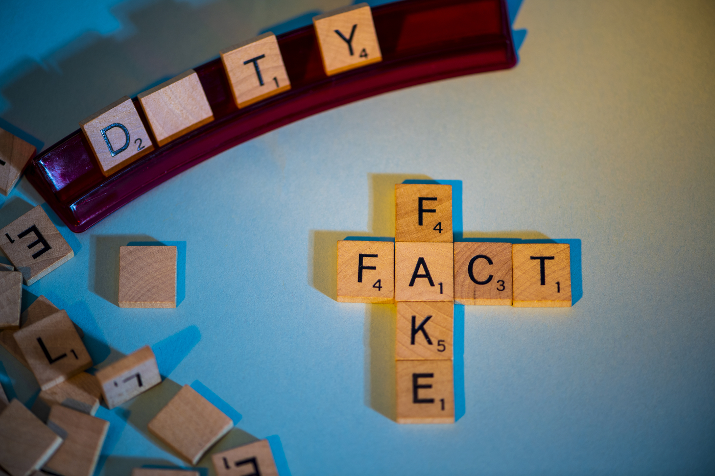 Scrabble letters spell out "fact" and "fake."