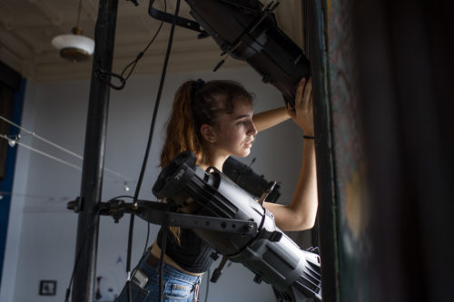 Northeastern theater and English double major Ciara McAloon adjusts the lights at the Apollinaire Theatre for the bilingual production of Romeo and Juliet. The play will be performed outdoors in Chelsea Square. Photo by Alyssa Stone/Northeastern University