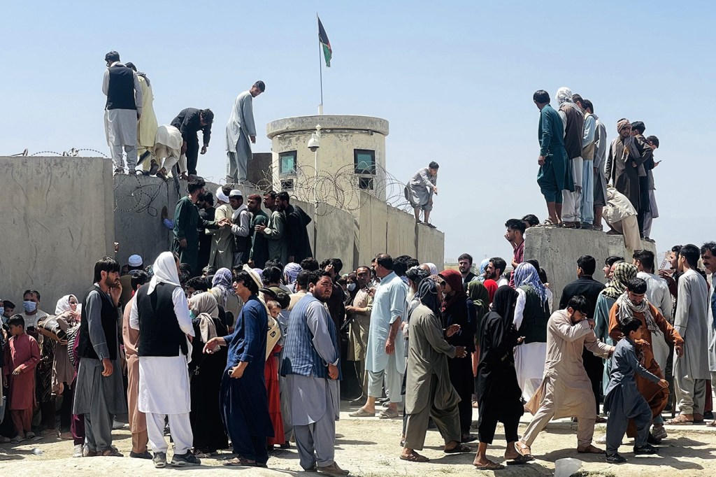 Afghan citizens gather near the airport in in Kabul as the Taliban close in