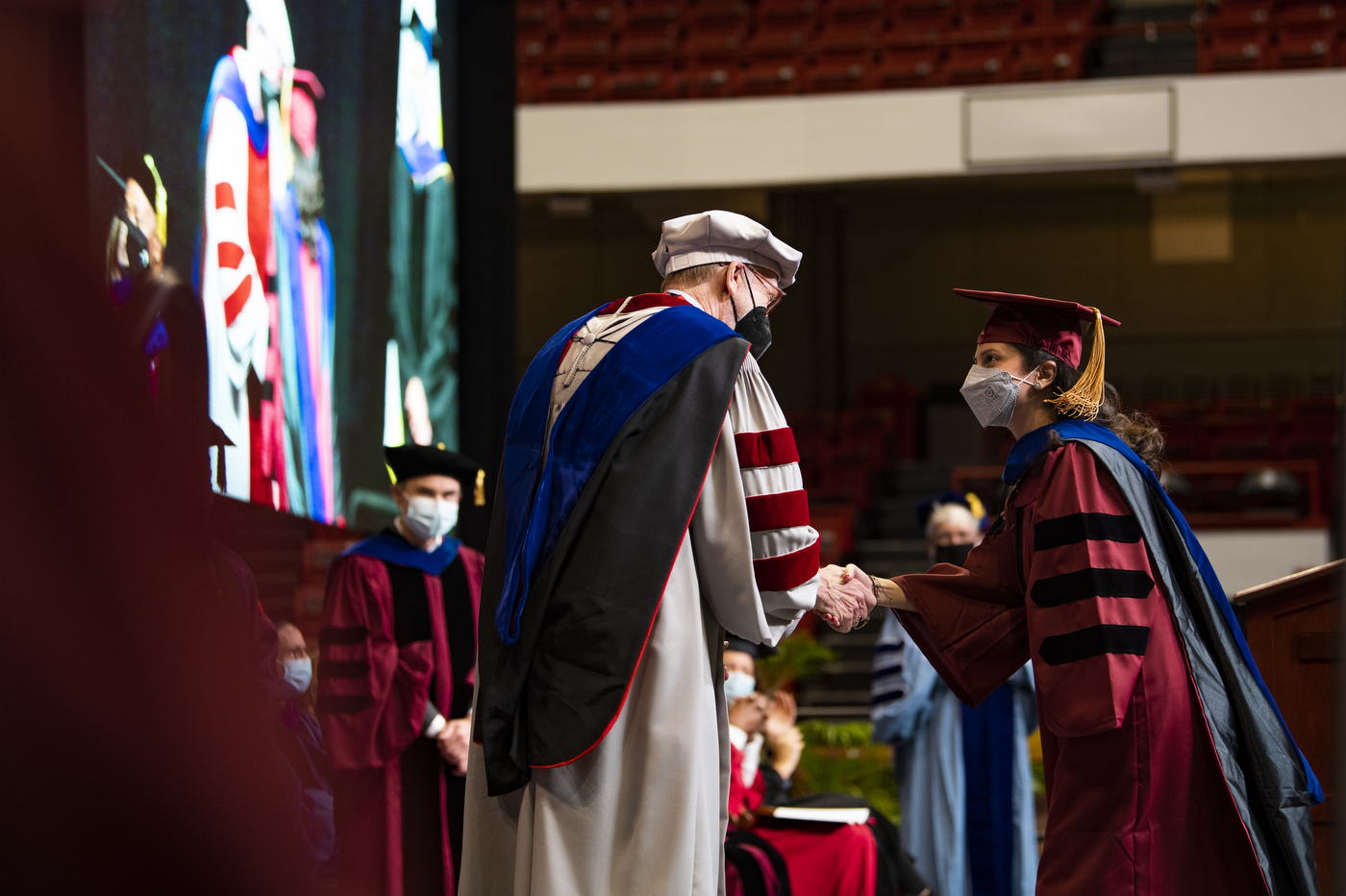 northeastern doctoral graduate shaking hands with advisor