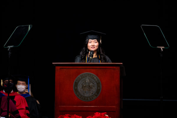 northeastern business graduate speaks at podium