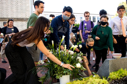 students place flowers on a northeastern university 9/11 memorial