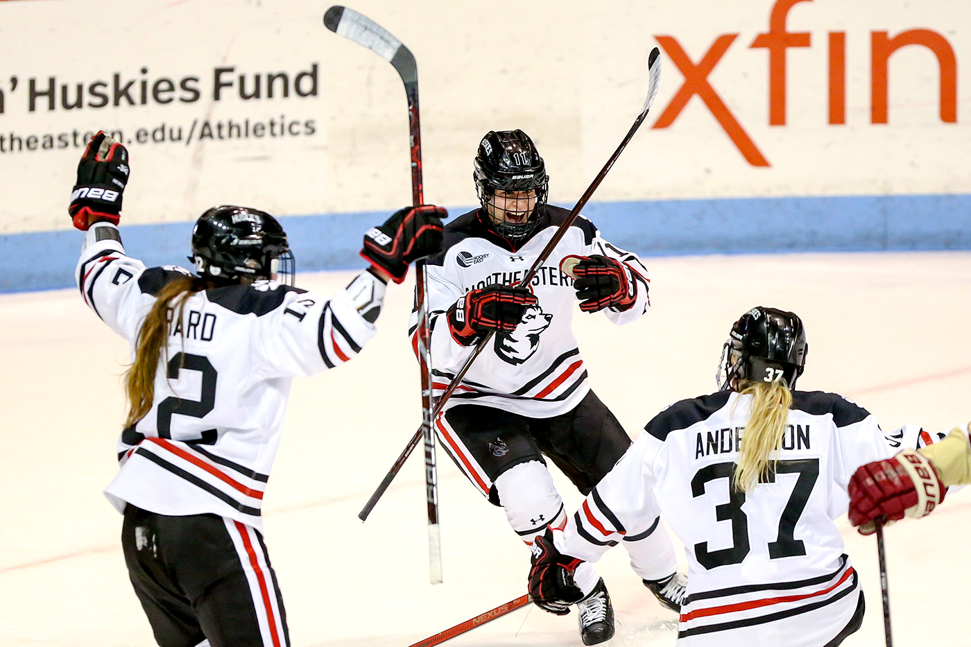 Northeastern's women's hockey team celebrates on the ice.