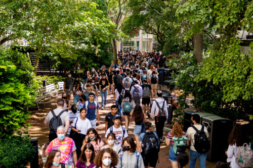 masked and unmasked northeastern students walking on campus