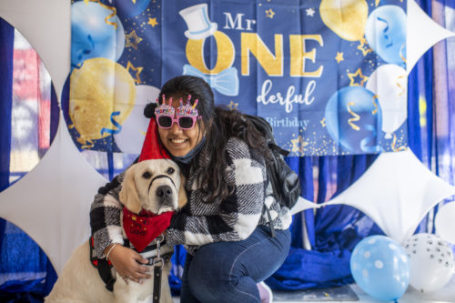 Romita Thally, an information systems student at Northeastern, poses for a photograph with Northeastern Police emotional support dog Cooper during his first birthday party in the Rainbow Tent. Photo by Alyssa Stone/Northeastern University
