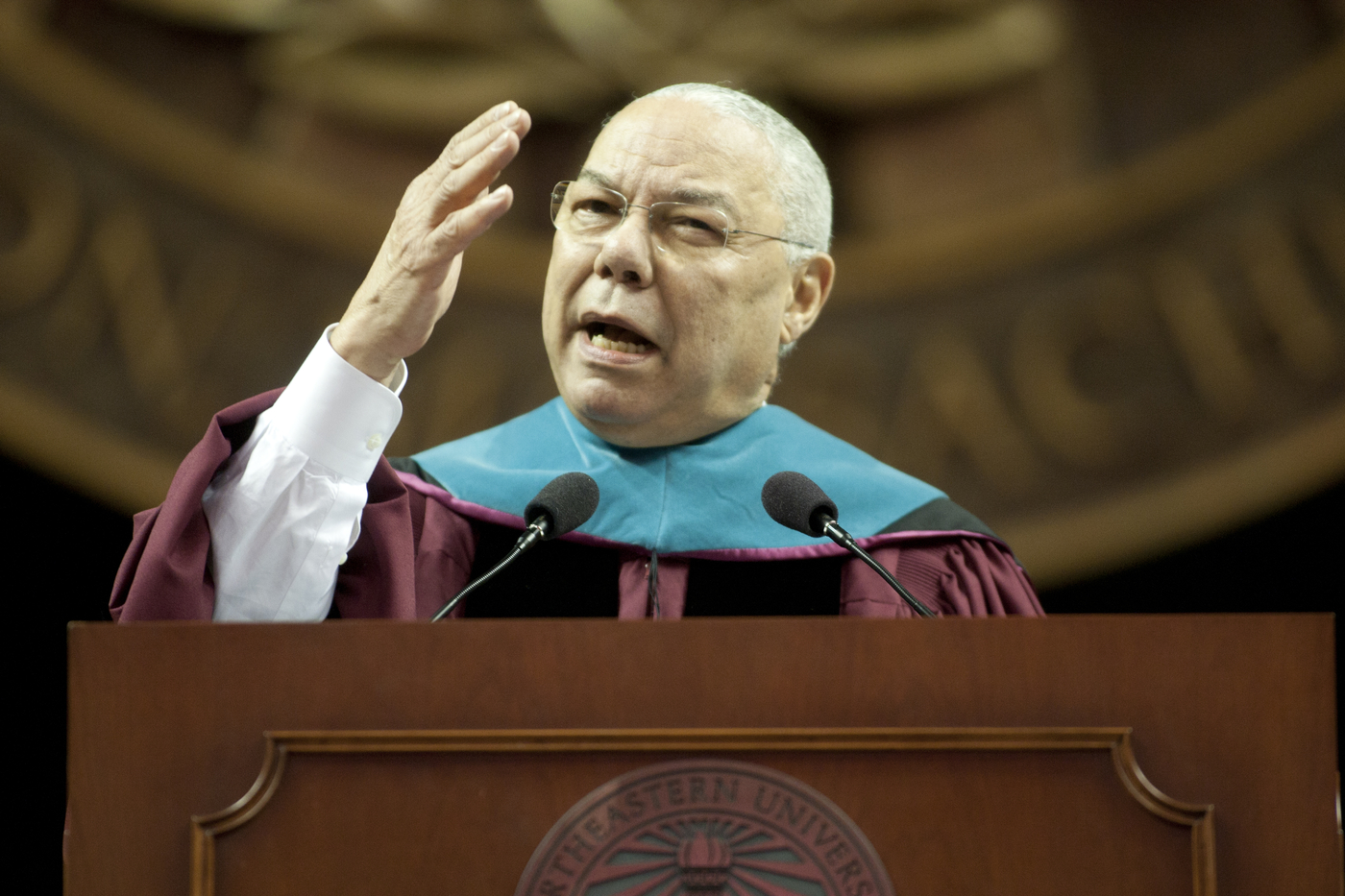Colin Powell in Commencement regalia, speaking at the podium