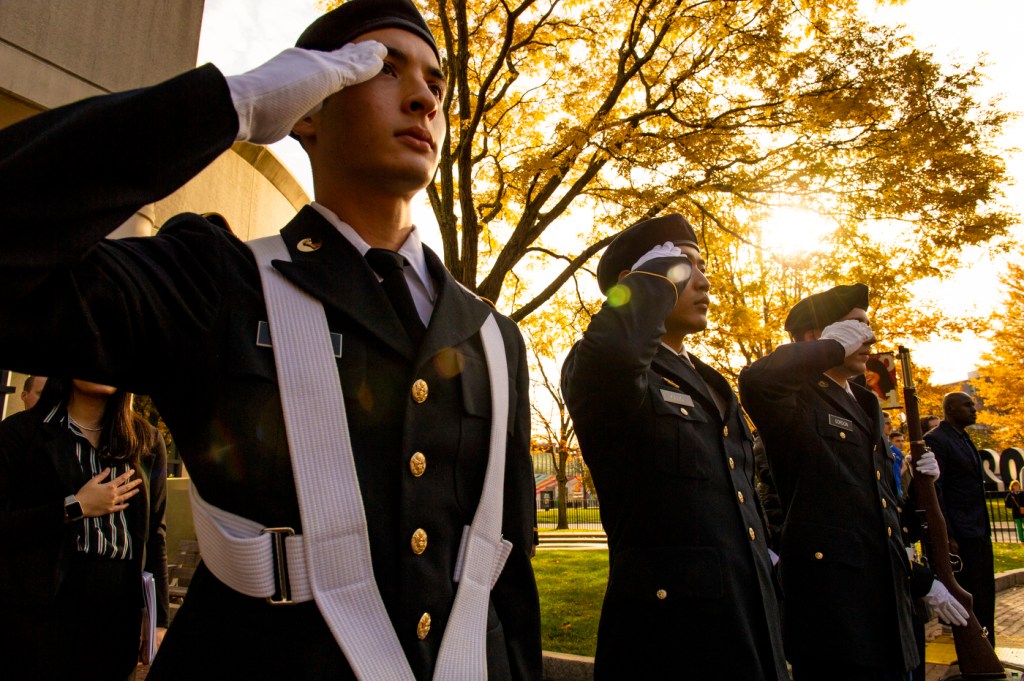 uniformed rotc students stand at salute