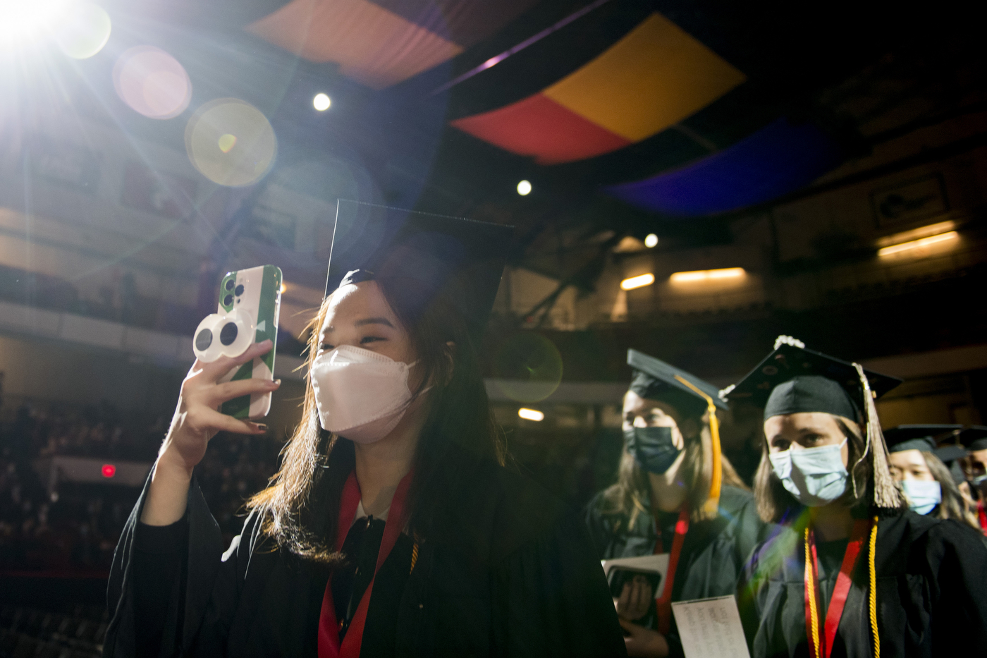 A graduate holds a phone