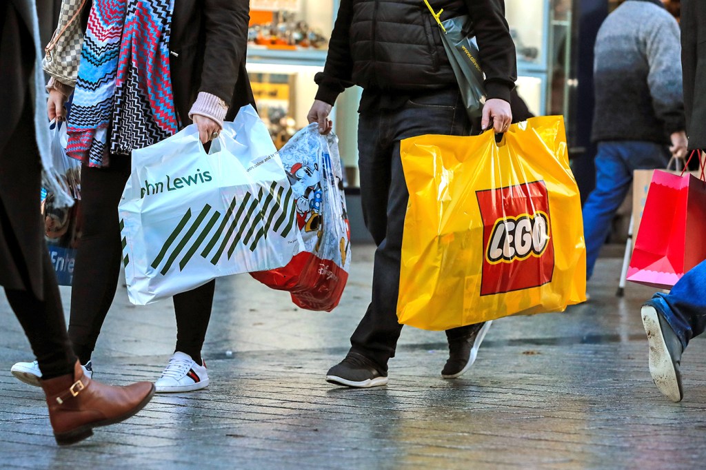 people walking holding shopping bags