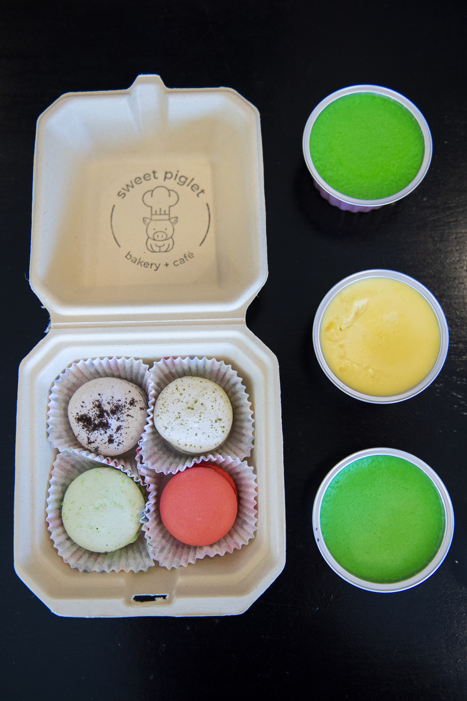 colorful macrons and creme brulee in takeaway containers